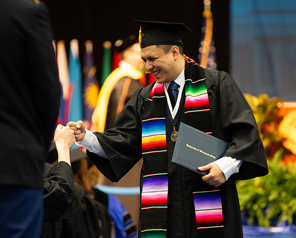 A student celebrates after receiving his diploma during a May commencement ceremony at UW-Stout.