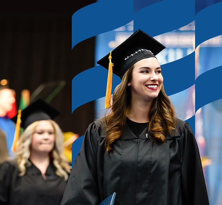 UW-Stout students walks with diploma at graduation ceremony.