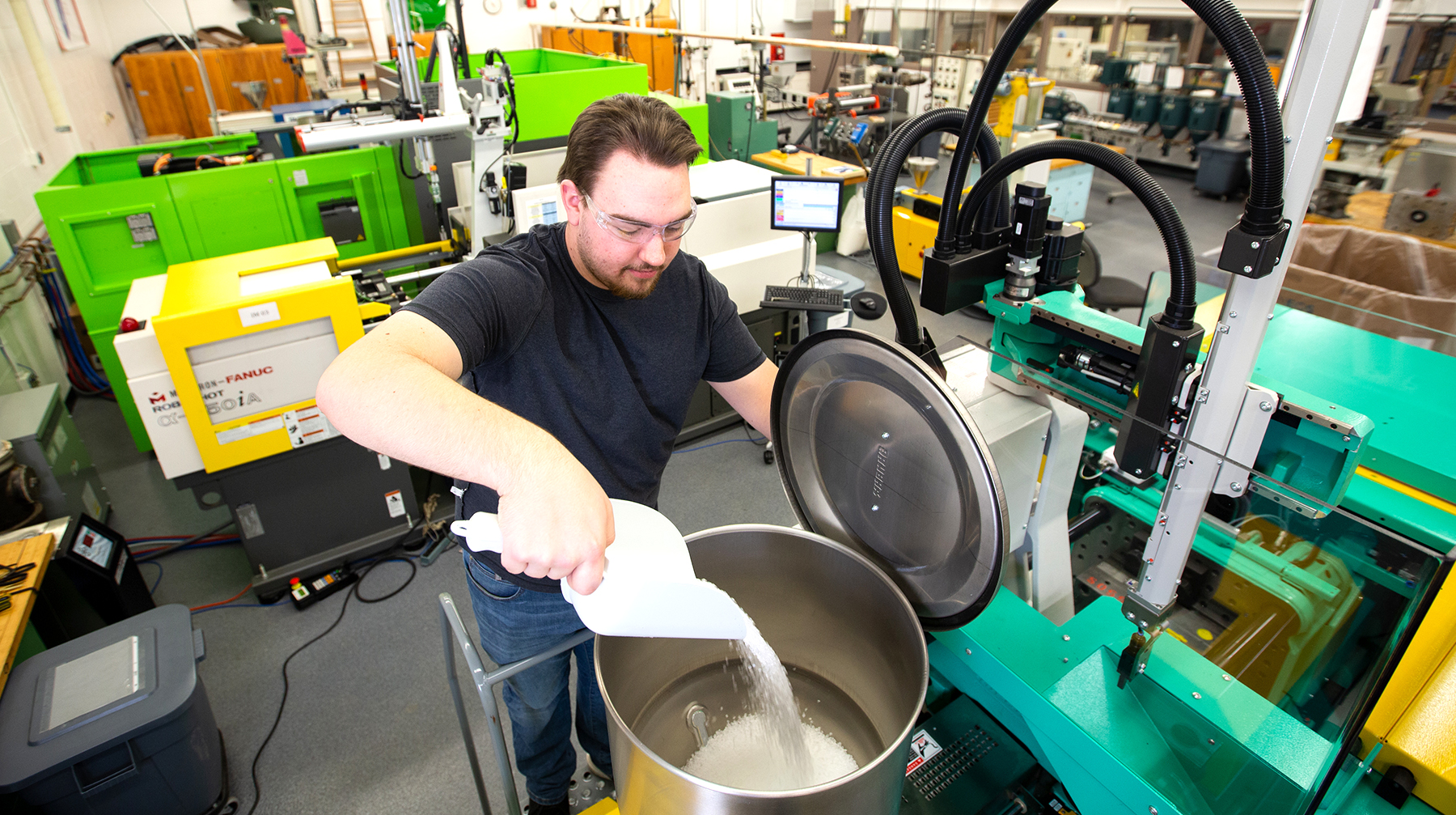 UW-Stout student engages with injection molding machine.
