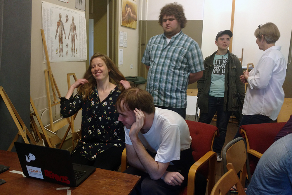 UW-Stout students show students from the Swedish Academy of Realistic Art how to program a video game.