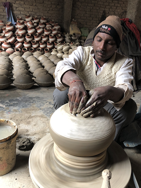 Jagmohan creates the neck of a water jar at his pottery production business in Uttam Nagar, India, near New Delhi. / Ceramics Monthly photo