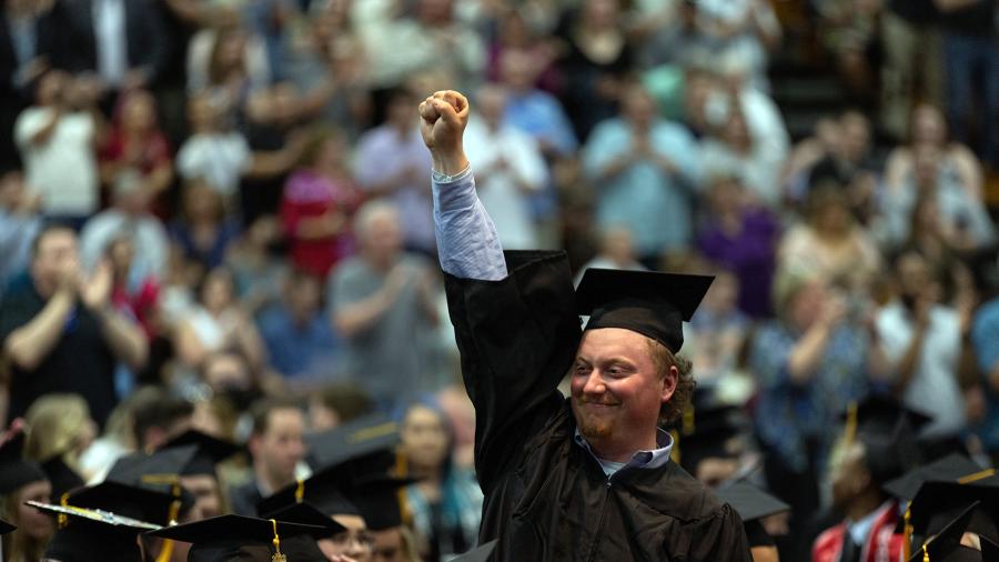 A student celebrates after graduating in spring 2022.