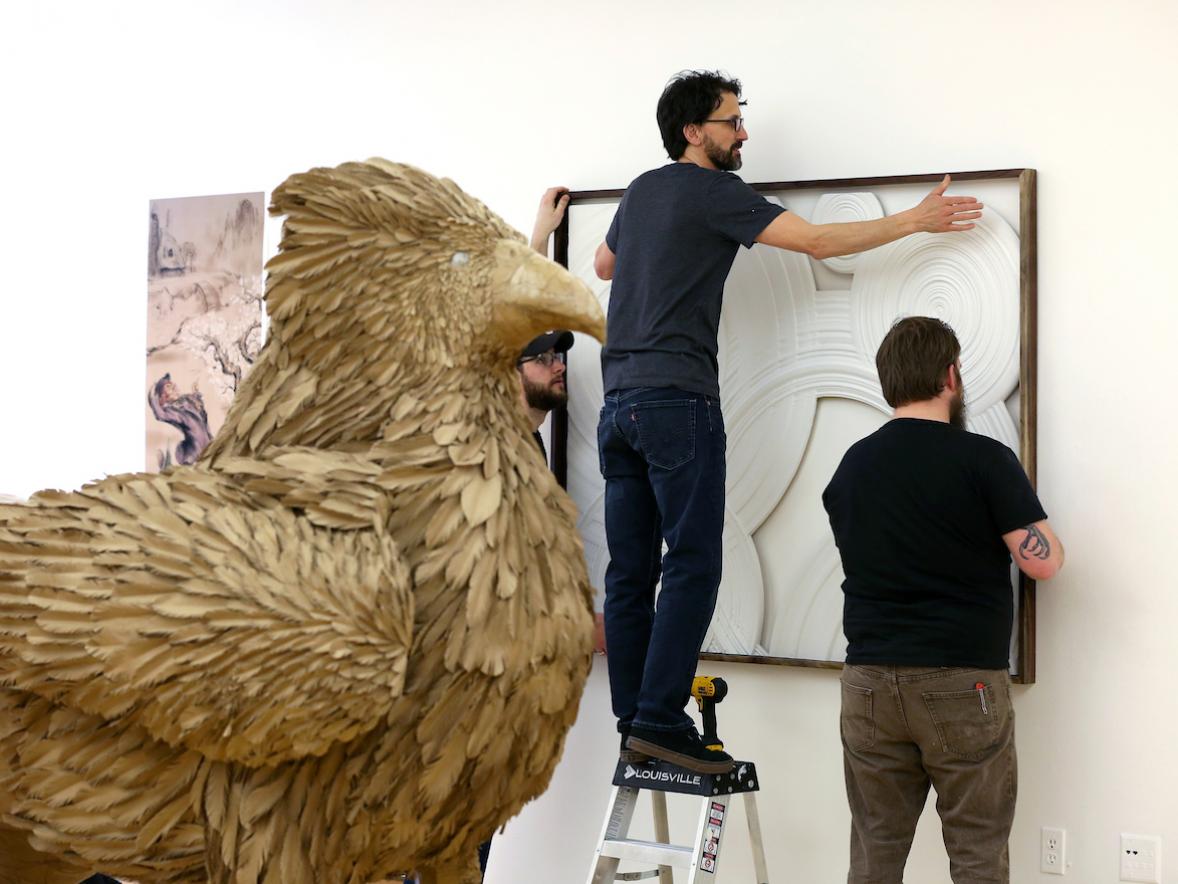 Robert Atwell, associate professor of foundations, (left) and others install the Year-end Juried Student Art Show in the Furlong Gallery Thursday, April 6, 2017. (UW-Stout Photo by Brett T. Roseman)