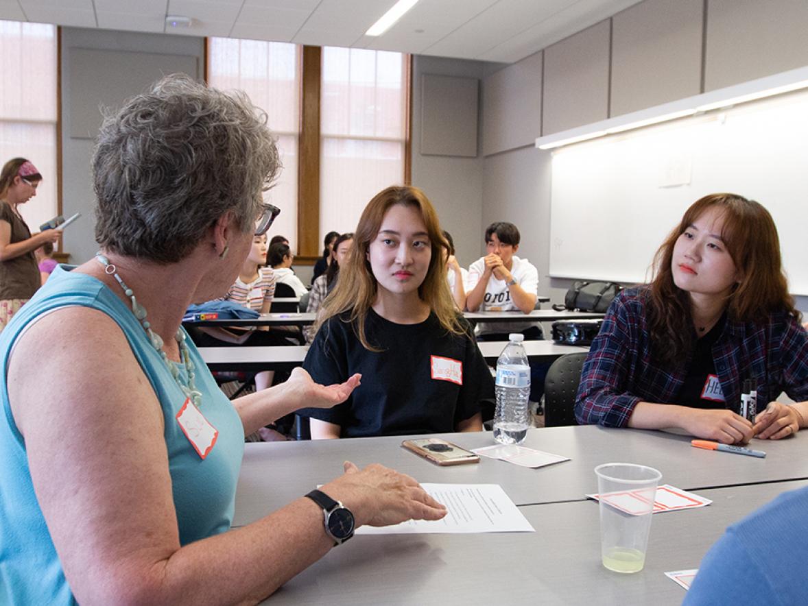 Sue Foxwell, at left, talks with South Korean students Sangha Lee and Heeju Jang during the conversations with international students. 