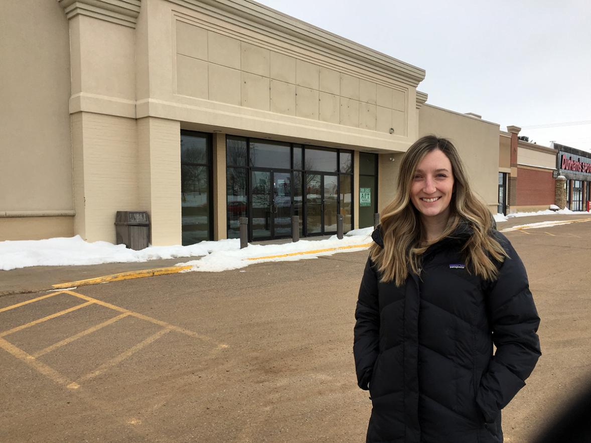 UW-Stout recent master’s degree graduate Nicolette Brehm outside the Shops Off Broadway mall in Menomonie. Brehm did her master’s degree creative thesis on turning empty shopping into senior living centers. / UW-Stout photo by Pam Powers